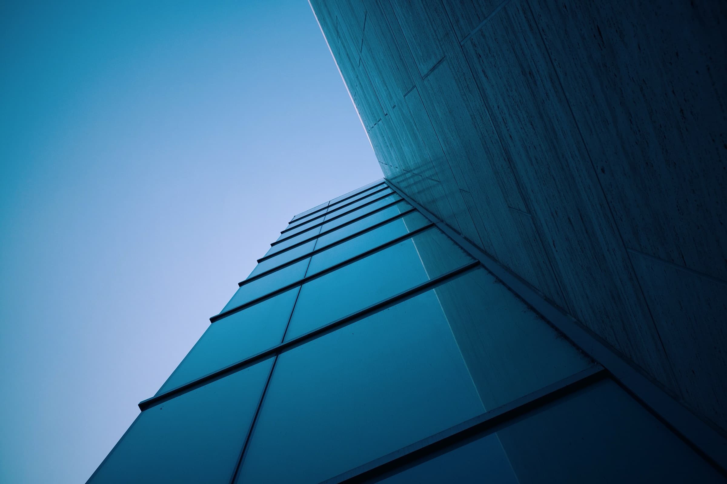Corner of a modern glass building facade against the sky